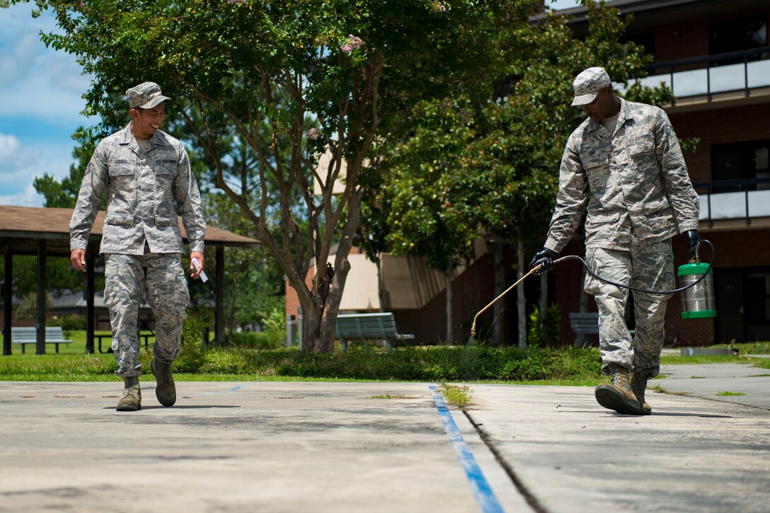 Airman 1st Class Jared King, right, 23d Civil Engineer Squadron (CES) water and fuel system maintenance apprentice, sprays weeds during the “A Day In A Life” program, Aug. 9, 2018, at Moody Air Force Base, Ga. The program challenges participating civil engineers to go behind-the-scenes to perform multiple jobs to better understand their fellow Airmen and better develop operational leaders. Airmen from the 23d CES who work in the entomology shop specialize in the eradication of species that are prone to carrying vector diseases, along with ensuring the aesthetic upkeep of the landscape on base. (U.S. Air Force photo by Airman 1st Class Erick Requadt)