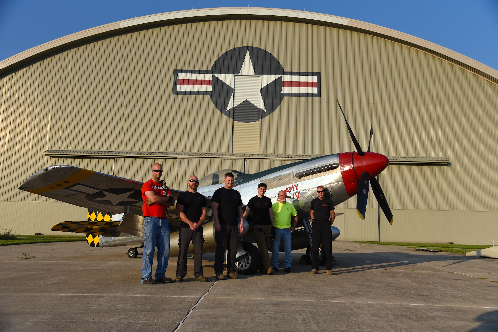 Museum restoration specialists(from left to right) Adam Naber, Chase Meredith, Nick Almeter, Casey Simmons, Roger Brigner, and Brian Lindamood pose for a photo with the North American P-51D Mustang at the National Museum of the U.S. Air Force on Aug. 14, 2018. They are well versed in a variety of skills ranging from machine and woodworking expertise to precision craftsmanship in sheet metal and painting. Their knowledge of aircraft spans years of technology -- from World War I fabric covered aircraft to the elite fighters of today's Air Force. (U.S. Air Force photo by Ken LaRock)