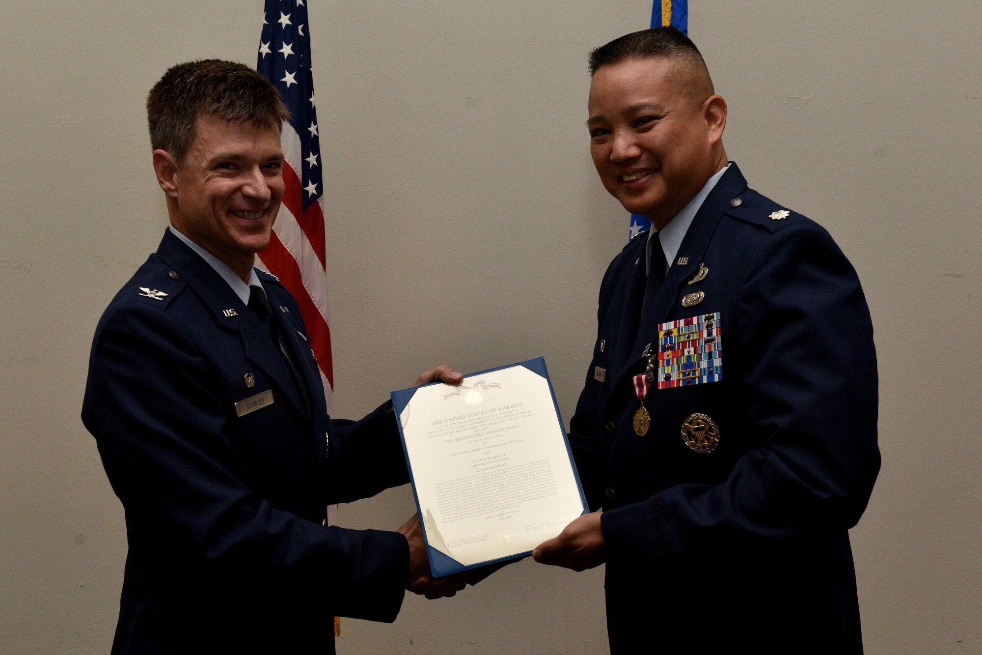 U.S. Air Force Col. Thomas Coakley, 17th Training Group commander, presents a meritorious service certificate to Lt. Col. Abraham Salomon, 17th Training Squadron outgoing commander, during the 17th TRSS Change of Command in the Event Center on Goodfellow Air Force Base, Texas, August 14, 2018. Salomon received the award for his outstanding service to the squadron. (U.S. Air Force photo by Senior Airman Randall Moose/Released)