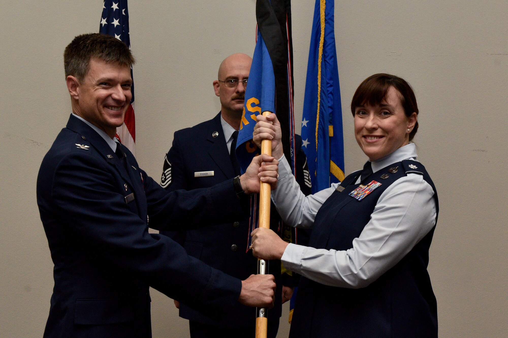 U.S. Air Force Col. Thomas Coakley, 17th Training Group commander, gives the guideon to Lt. Col. Amber Saldaña, 17th Training Squadron incoming commander, during the 17th TRSS Change of Command in the Event Center on Goodfellow Air Force Base, Texas, August 14, 2018. The passing of the guideon symbolizes the passing of command from one commander to the next. (U.S. Air Force photo by Senior Airman Randall Moose/Released)