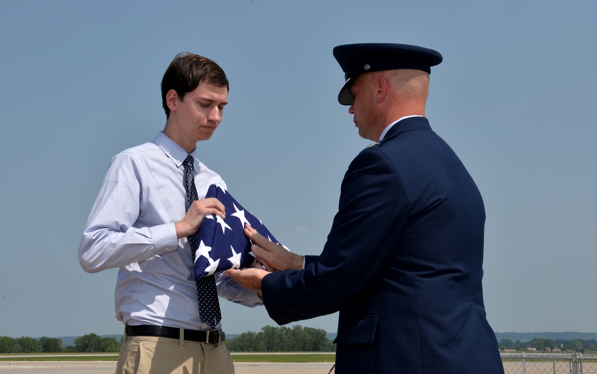 Col. Michael Manion, 55th Wing commander, hands John Offutt an American flag as part of a ceremony held Aug. 12, 2018 during the Defenders of Freedom Air and Space Show at Offutt Air Force Base, Nebraska. The ceremony honored the late Lt. Jarvis Offutt who the base is named after. He was the first Omaha native to die in WWI when his plane was shot down over France 100 years ago. John Offutt is the great-great nephew of Lt. Jarvis Offutt and recently returned to the area to attend University of Nebraska Omaha. (U.S. Air Force photo by Josh Plueger)