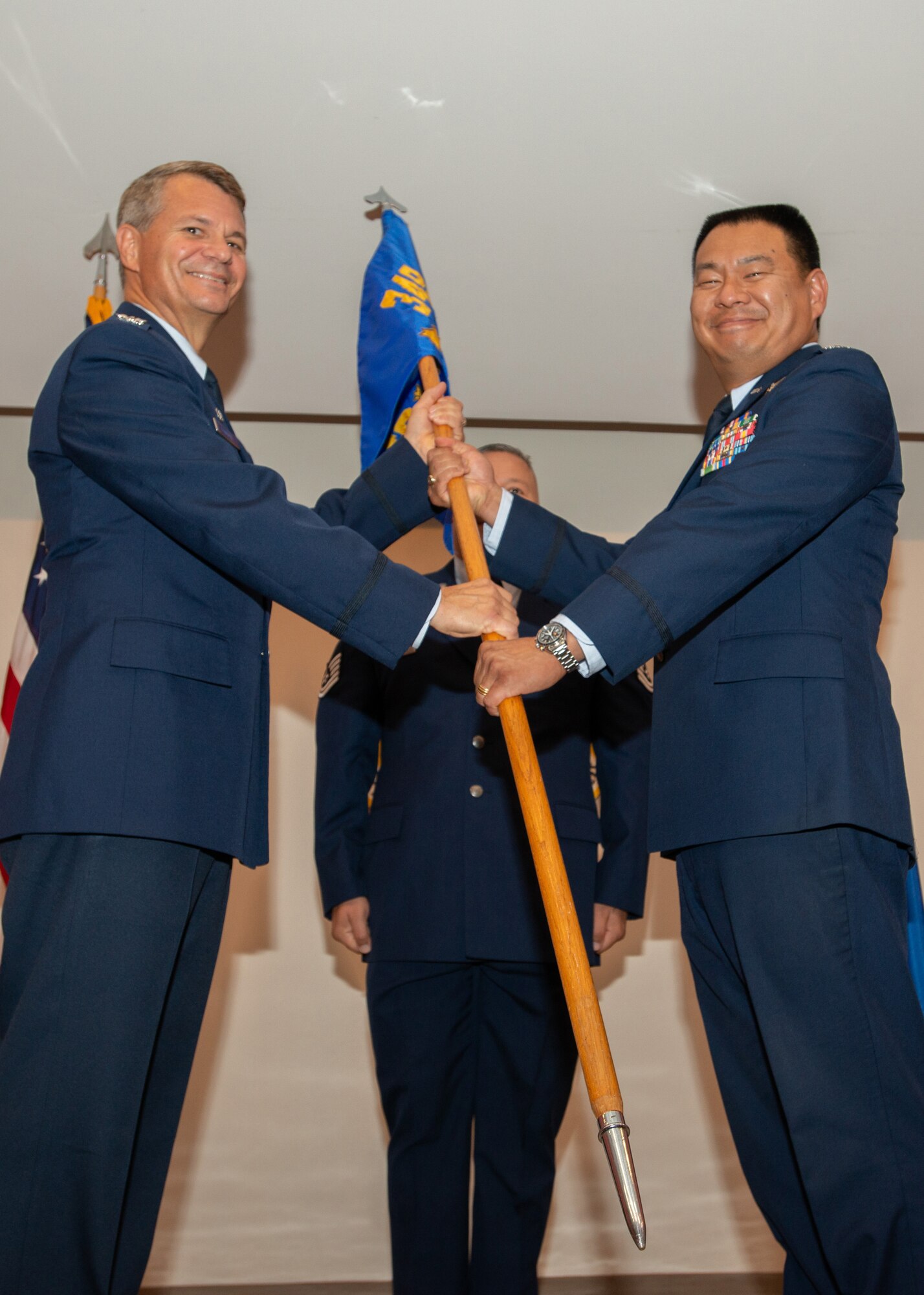 Col. David L. Huang pinned on his new rank, and accepts the 349th Aeromedical Staging Squadron’s guidon from Col. John Langell, commander of the 349th Medical Group, during a assumption of command ceremony at Travis Air Force Base, Calif., August 11, 2018.
