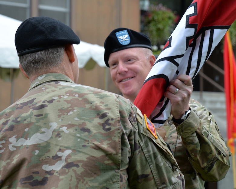 Col. Phillip Borders receives the Corps guidon from Brig. Gen. Thomas Tickner, commanding general of the U.S. Army Corps of Engineers - Pacific Ocean Division, signifying the start of his command of the Alaska District today during a ceremony at the headquarters building on Joint Base Elmendorf-Richardson.