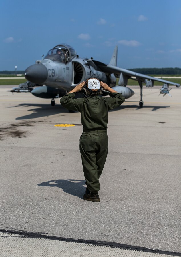 A Marine with Marine Attack Squadron (VMA) 311 directs an AV-8B Harrier II during Exercise Northern Lightning at Volk Field Counterland Training Center, Camp Douglas, Wis. Aug. 13. Exercise Northern Lightning 2018 allows the Air Force, Marine Corps and Navy to strengthen interoperability between services and gives the different branches a greater understanding of aviation capabilities within a joint fighting force. (U.S. Marine Corps photo by Sgt. David Bickel)