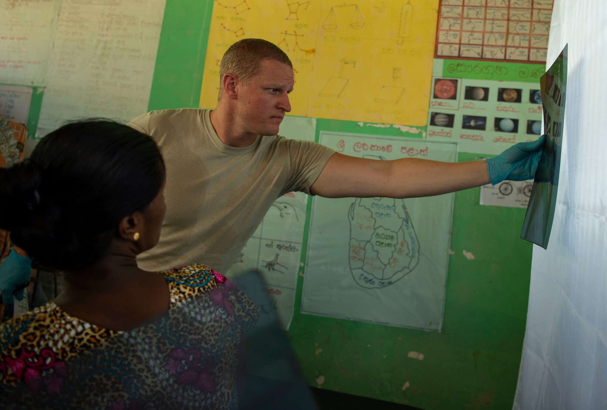 U.S. Air Force Capt. Evan Carson, 673rd Medical Operations Squadron, Joint Base Elmendorf-Richardson, Alaska, examines x-rays of a patient during the first day of the  Pacific Angel (PAC ANGEL) 18-4 health services outreach event in Vavuniya, Sri Lanka, Aug. 13, 2018.