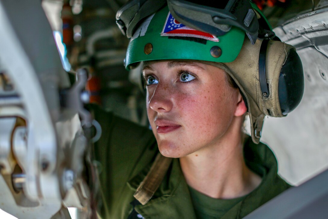 A Marine mechanic works on a plane.