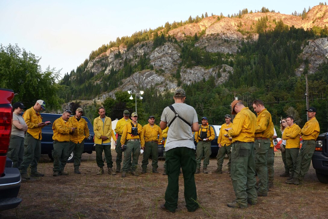 Airmen receive an end of day brief after fighting a wildfire.