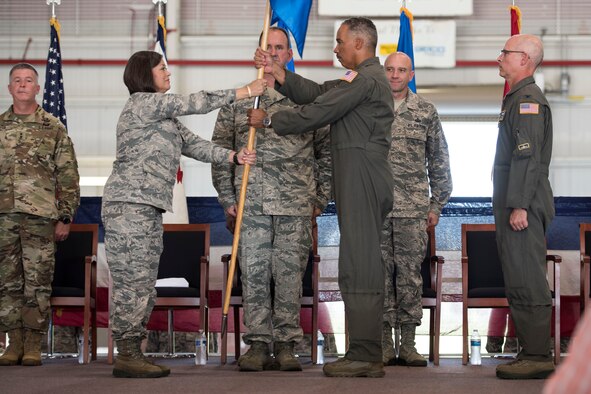 West Virginia National Guard Assistant Adjutant General - Air, Brig. Gen. Paige Hunter, ceremoniously hands the 167th Airlift Wing guidon to Col. David Cochran as he assumes command of the wing from Col. Shaun Perkowski, left, during a change of command ceremony, Aug. 5, at the Martinsburg, W.Va. air base. (U.S. Air National Guard photo by Senior Master Sgt. Emily Beightol-Deyerle)