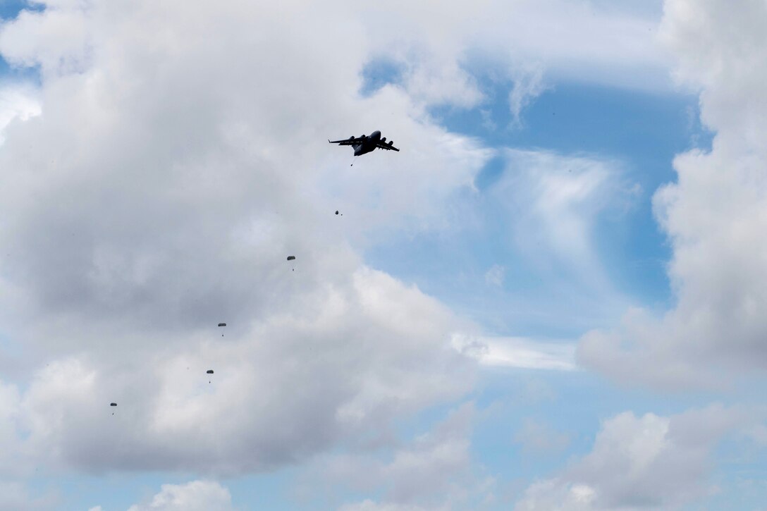Australian soldiers perform static line jumps from a U.S. C-17 Globemaster III.