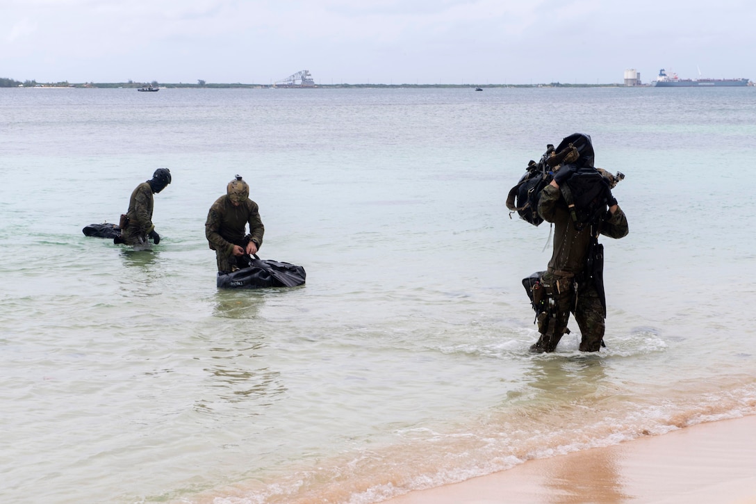 Australian army soldiers swim to shore.