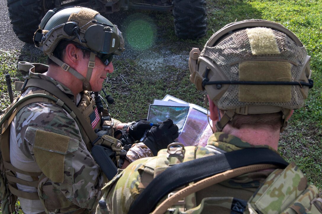 A U.S. sailor and Australian soldier read a map.