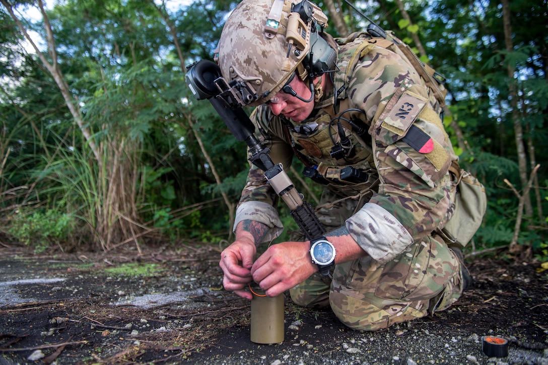 A sailor removes the fuze from a grenade.