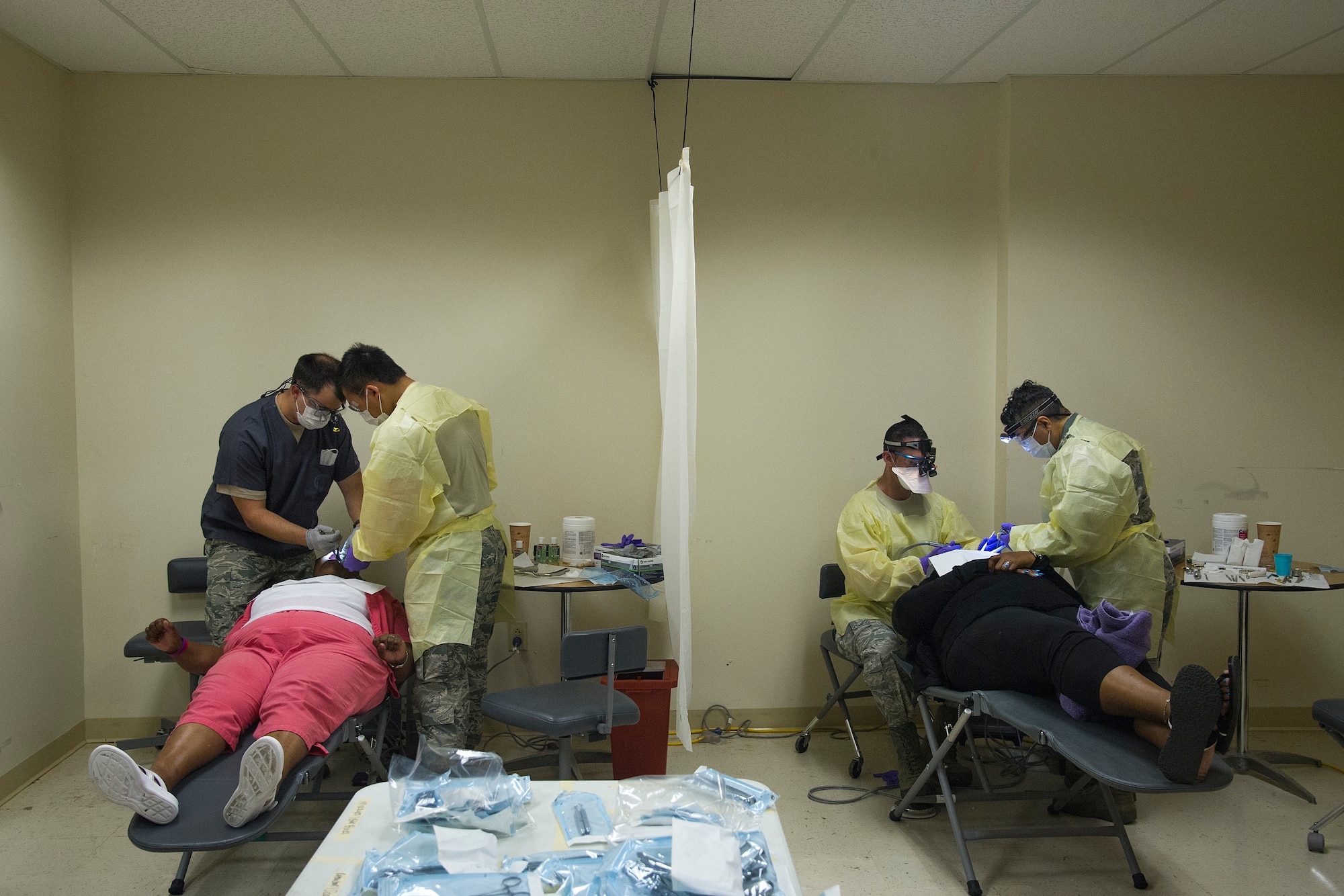 U.S. Air Force Capt. Patrick Noland a dentist for the Air National Guard’s 167th Airlift Wing Medical Group, W. Va., and Senior Airman Gary Vang a dental technician with the Air Force Reserve’s 934th Aeromedical Staging Squadron, Minneapolis, Minn., (left) and  Lt. Col. Javad Aghalloo, of San Diego, Calif., a dentist for the 452nd Aeromedical Staging Squadron, March Air Reserve Base, Calif., and Tech. Sgt. Ignacio Cabrera, of Lagrange, Ga., a dental technician for the 94th Aeromedical Staging Squadron, Dobbins Air Reserve Base, Ga., provide dental treatment for a local patients in Washington, Ga., July 12, 2018, during the East Central Georgia Innovative Readiness Training. An IRT provides hands-on, real-world training to improve readiness and survivability for servicemembers in complex contingency environments while providing key services for American communities. (U.S. Air Force photo by Master Sgt. Theanne Herrmann)