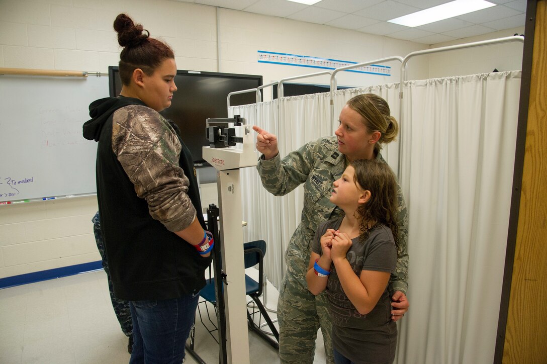 U.S. Air Force Capt. Lori Wyatt, of Augusta, W. Va., a clinical nurse with the West Virginia Air National Guard’s 167th Medical Group, Martinsburg, W.Va., shows a patient how to use a medical scale to check her sister’s weight during the East Central Georgia Innovative Readiness Training in Crawfordville, Ga., July 13, 2018. An IRT provides hands-on, real-world training to improve readiness and interoperability for service members in complex contingency environments while providing key services for American communities. (U.S. Air Force photo by Master Sgt. Theanne Herrmann)