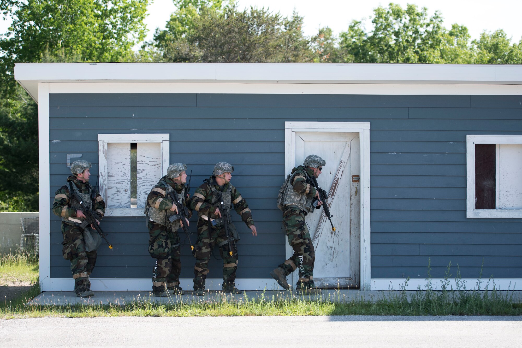 Four Airmen assigned to the 167th Security Forces Squadron prepare to enter a building in a mock village during a deployment training exercise at the Alpena Combat Readiness Training Center in Michigan, June 10-14, 2018. Approximately 200 members of the 167th Airlift Wing participated in the event. (U.S. Air National Guard photo by Tech. Sgt. Jodie Witmer)