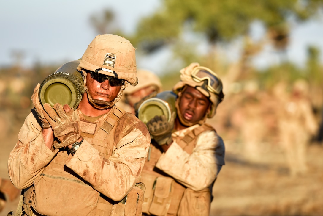 Lance Cpls. Justin T. Winn and Christophe Jackson, field artillery cannoneers with Mike Battery, 3rd Battalion, 11 Marine Regiment, 1st Marine Division, carry rounds for an M777 Howitzer during training Aug. 8, 2018, at Mount Bundey, Northern Territory, Australia.