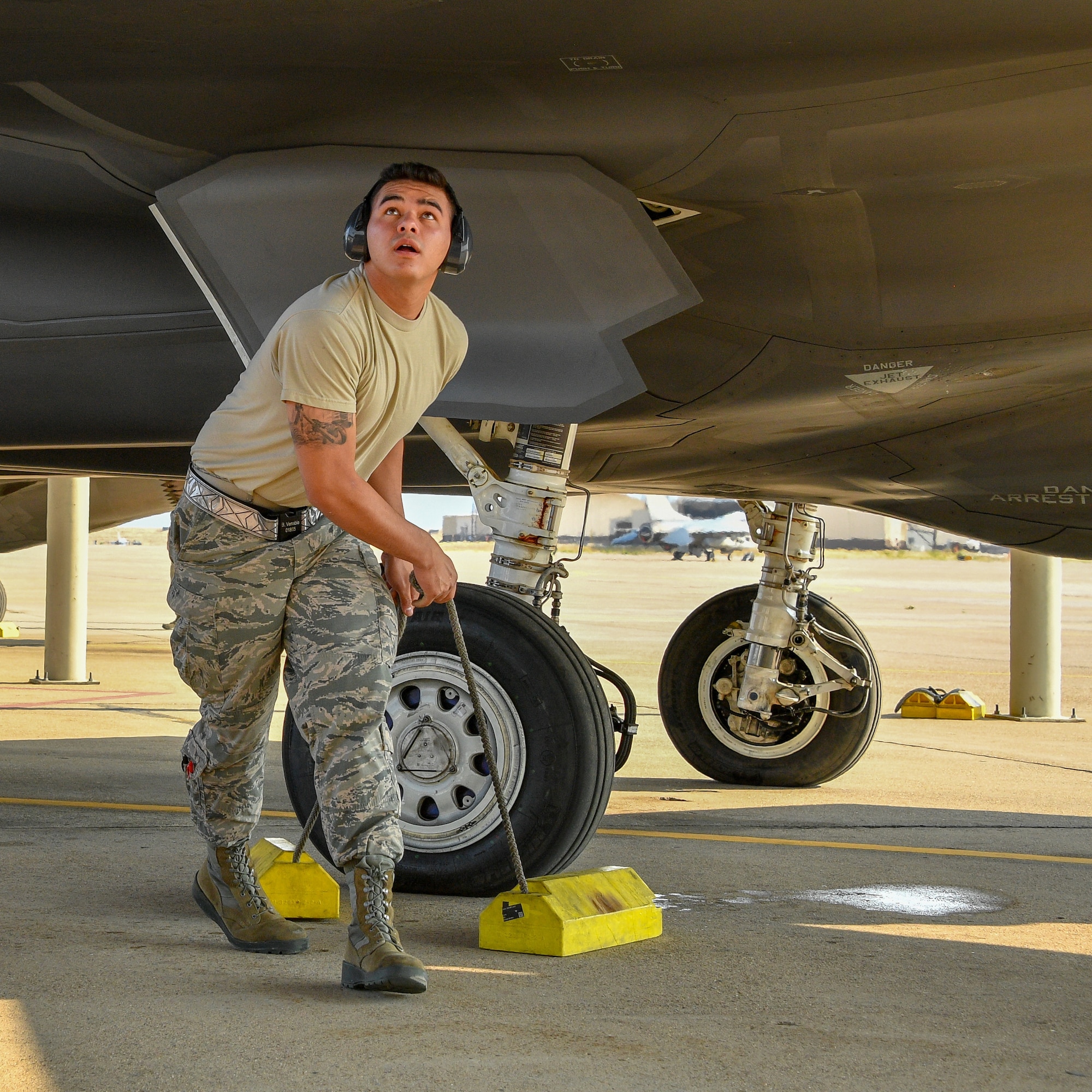 Airman 1st Class Brennan Venable removes chocks from an F35A Lightning II prior to launch at Hill Air Force Base, Utah, July 31, 2018. (U.S. Air Force photo by R. Nial Bradshaw)