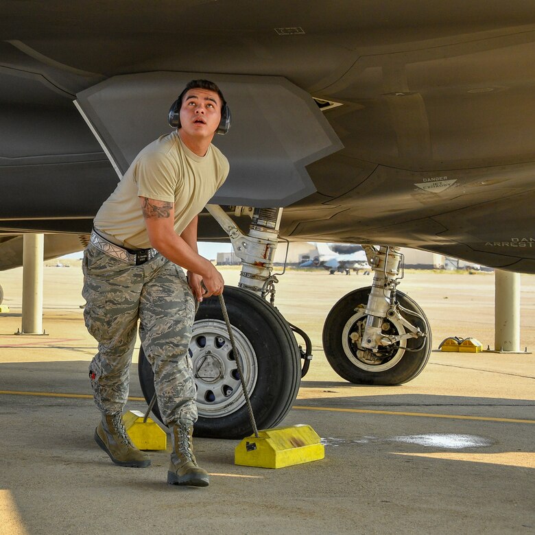 Airman 1st Class Brennan Venable removes chocks from an F35A Lightning II prior to launch at Hill Air Force Base, Utah, July 31, 2018. (U.S. Air Force photo by R. Nial Bradshaw)