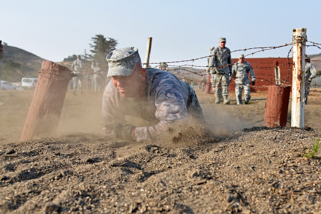 U.S. Air National Guard Chief Master Sgt. Scott Whitley, from the 161st Security Forces Squadron, crawls through a portion of the U.S. Army’s confidence course during an annual training event at Camp San Luis Obispo, California, July 31, 2018. The 10-day annual-training exercise brought together Security Forces members from four Air National Guard units in Arizona and Illinois to improve weapons, land navigation, and tactical movement skills. (U.S. Air National Guard photo by Staff Sgt. Dillon Davis)