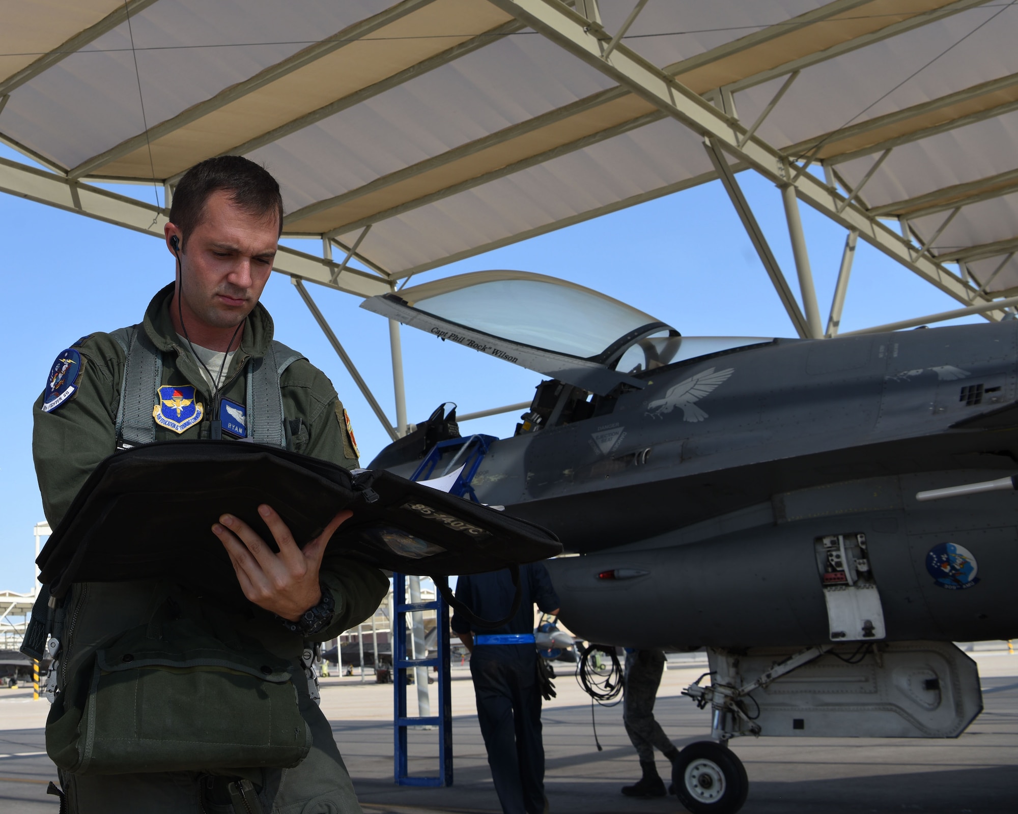 U.S. Air Force Capt. Ryan Neely, 309th Fighter Squadron B flight commander, reviews procedures before inspecting an F-16 Fighting Falcon, Aug. 14, 2018 at Luke Air Force Base, Ariz.