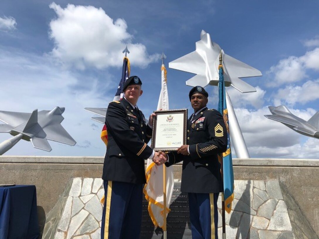 Army Col. Rick Ellis, 8th Theater Sustainment Command deputy commander, present Army Master Sgt. Larry Hogan the certificate of retirement during a ceremony Aug. 14 at Joint Base Pearl Harbor Hickam Missing Man Formation.  Photo by Dr. John Hamilton