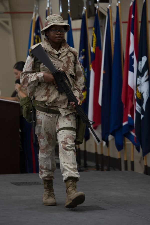 A U.S. Marine with Marine Aircraft Group 39, 3rd Marine Aircraft Wing, dons the 2006 desert battle dress uniform representing the first female Marine officer killed in Operation Iraqi Freedom, Maj. Megan McClung, during the women Marines’ 100th year anniversary pageant at Marine Corps Air Station Camp Pendleton, Calif., Aug. 13. Marines displayed 15 different uniforms showcasing eras of history from the last 100 years ranging from the first female Marine, Opha Mae Johnson, to the first female Marine to check into the School of Infantry - West, Pfc. Kira Kozik. (U.S. Marine Corps photo by Lance Cpl. Juan Anaya)