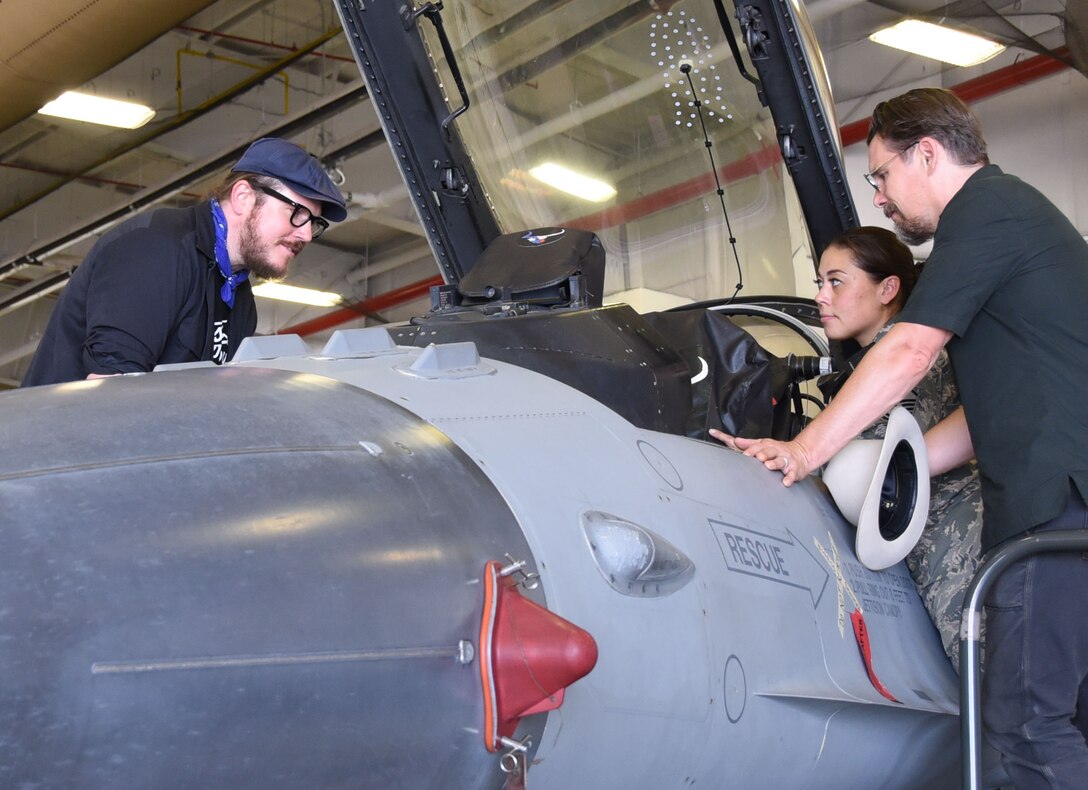 Director and Oscar-nominated actor Ethan Hawke and fellow actor and musician Ben Dickey look inside an F-16 Fighting Falcon while Master Sgt. Michelle Boutell, 301st Maintenance production superintendent, shares details about the jet during their visit to the 301st Fighter Wing, Aug. 15, 2018. The two visited Naval Air Station Fort Worth Joint Reserve Base, Texas to premiere their latest movie, Blaze, for service members and their families. (U.S. Air Force photo by Melissa Harvey)