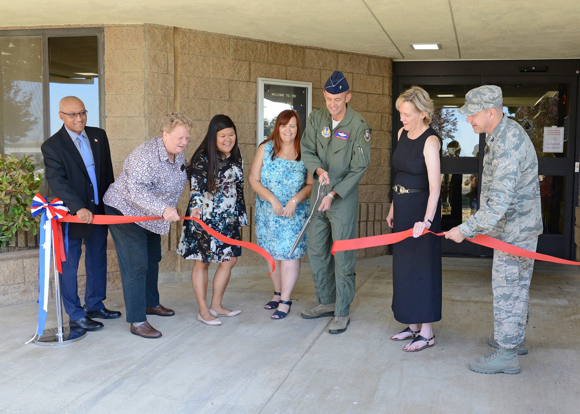 From left to right: Murray Westley, 412th Civil Engineer Squadron director; Gwyneth Bown, 412th Force Support Squadron Child and Youth Programs Flight chief; Colleen Evangelista-Weeks, 412th FSS; Kristen Burks, 412th FSS; Brig. Gen. E. John Teichert; 412th Test Wing commander; Janice Hollen, 412th FSS director; and Col. Jeffry Hollman, 412th Mission Support Group commander; cut the ceremonial red ribbon to officially reopen the School Age Annex Aug. 15. (U.S. Air Force photo by Kenji Thuloweit)
