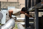 U.S. Air Force Senior Airman Frank Galambos, 51st Civil Engineer Squadron heating, ventilating and air conditioning journeyman, checks a cooling unit for one of the dorms at Osan Air Base, Republic of Korea, Aug. 13, 2018. With 42 members – 24 military and 18 civilian – assigned to the HVAC flight, they were able to close approximately 1,500 work orders in three months. (U.S. Air Force photo by Senior Airman Kelsey Tucker)
