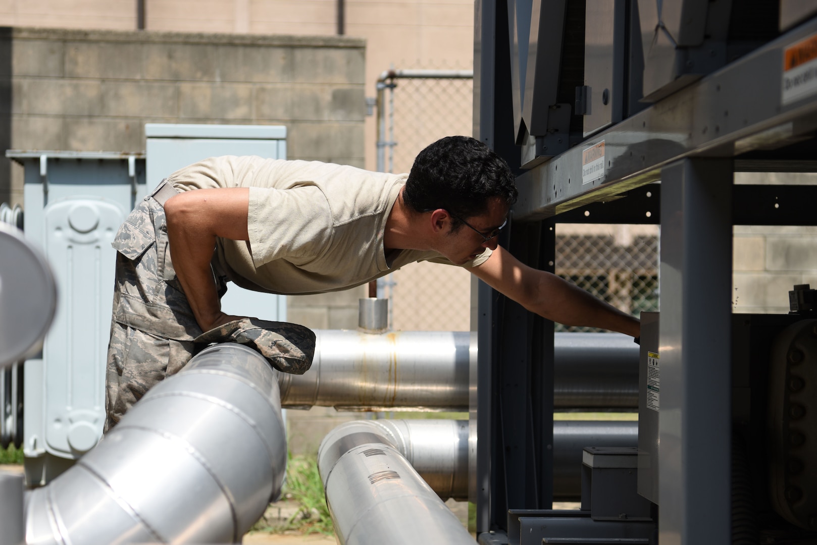 U.S. Air Force Senior Airman Frank Galambos, 51st Civil Engineer Squadron heating, ventilating and air conditioning journeyman, checks a cooling unit for one of the dorms at Osan Air Base, Republic of Korea, Aug. 13, 2018. With 42 members – 24 military and 18 civilian – assigned to the HVAC flight, they were able to close approximately 1,500 work orders in three months. (U.S. Air Force photo by Senior Airman Kelsey Tucker)