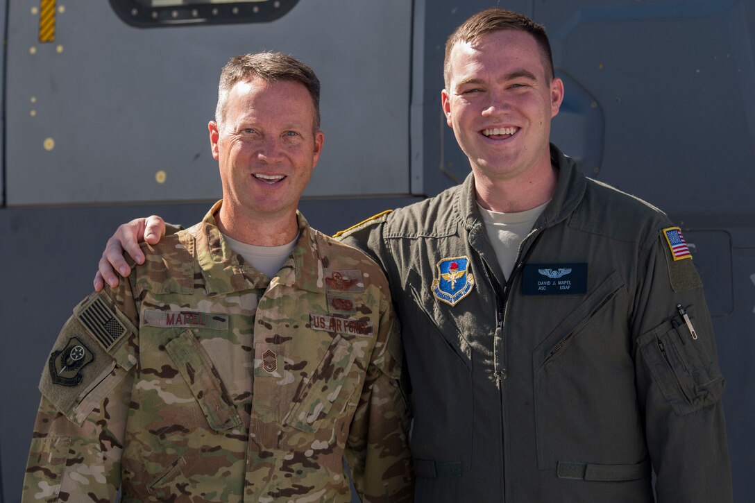 Two airmen stand next to each other as they pose for a picture.