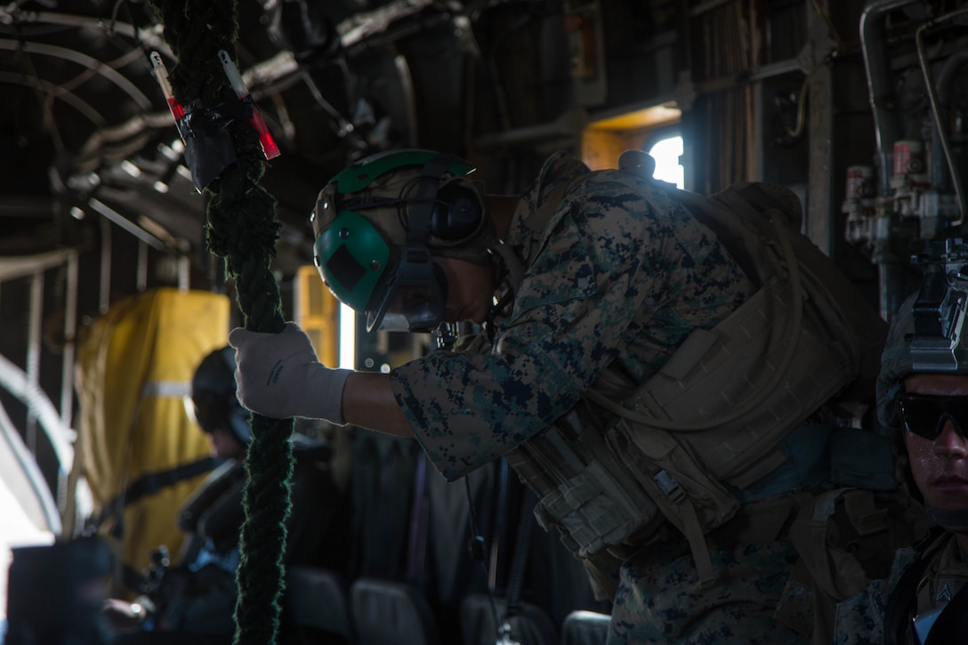 Cpl. Antonio Rojas, a fast-roping master with Amphibious Raids Branch, Expeditionary Operations Training Group, I Marine Expeditionary Force, holds onto the rope while over Marine Corps Base Camp Pendleton, Calif., Aug. 10. Fast-rope training is used to quickly insert Marines into an objective area. HMH-465 conducts training with EOTG to assist infantry Marines performing fast-rope training from a helicopter.