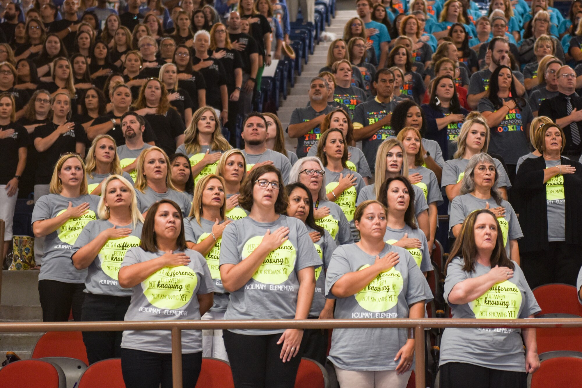 Faculty from Holiman Elementary School stand for the national anthem during the San Angelo Independent School District’s annual convocation at the Foster Communications Coliseum, San Angelo, Texas, Aug. 15, 2018. The event signified the kickoff of the 2018 to 2019 school year. (U.S. Air Force photo by Aryn Lockhart/Released)