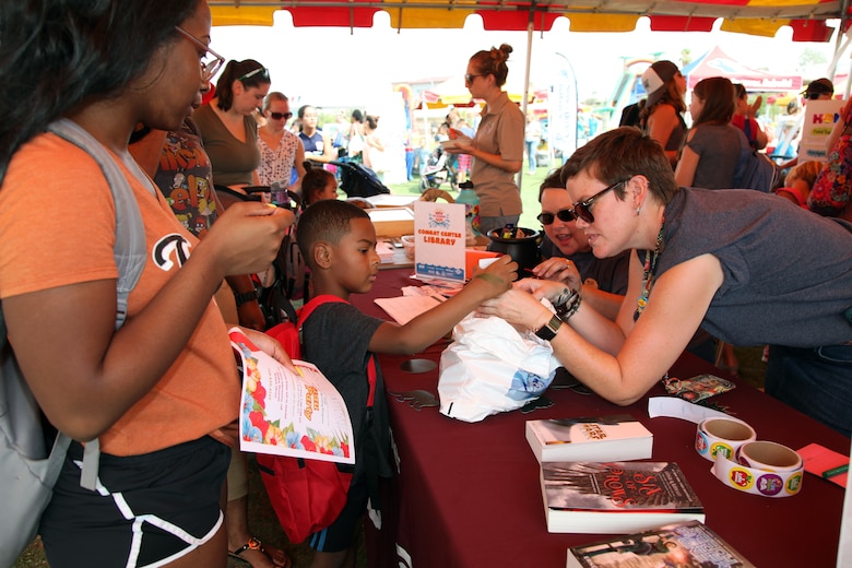 Kelley Loftis, right, and Crystal Dean of the Combat Center Library interact with family members during the Back to School Bash at Victory Field, Marine Corps Air Ground Combat Center, Twentynine Palms, Calif., Aug. 10, 2018. About 1,500 attended the event hosted by Marine Corps Community Services and the Combat Center School Liaison. (Marine Corps photo by Kelly O'Sullivan)