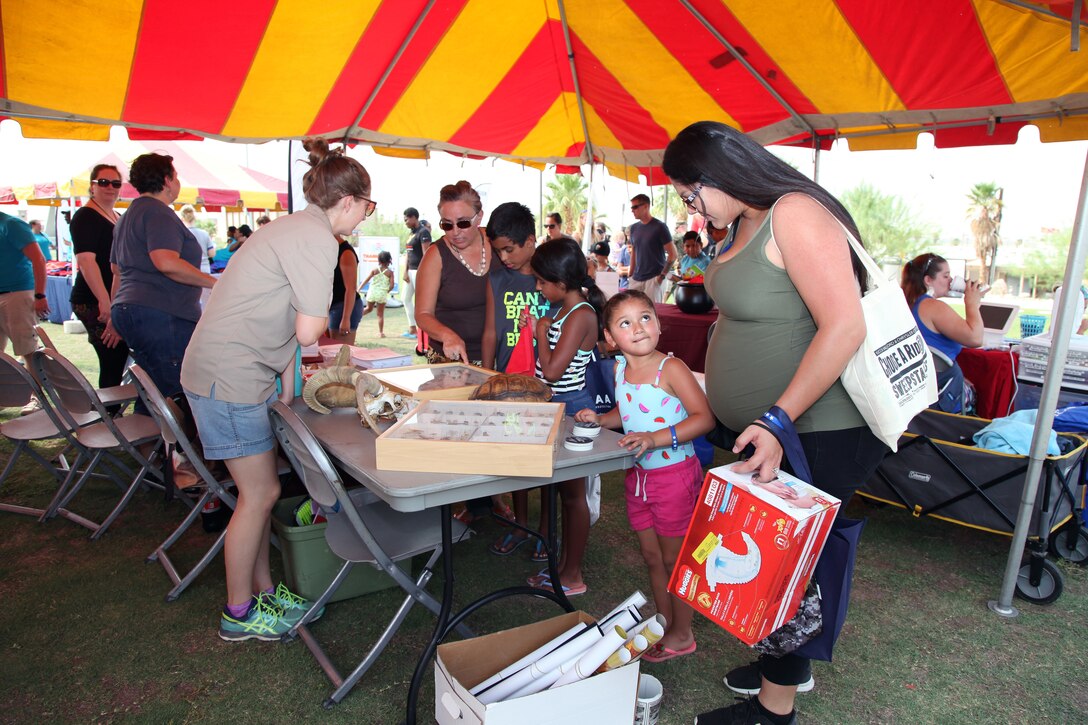 Family members crowd around the Environmental Affairs booth to learn about desert animals, insects and reptiles during the Back to School Bash at Victory Field, Marine Corps Air Ground Combat Center, Twentynine Palms, Calif., Aug. 10, 2018. About 1,500 attended the event hosted by Marine Corps Community Services and the Combat Center School Liaison. (Marine Corps photos by Kelly O'Sullivan)