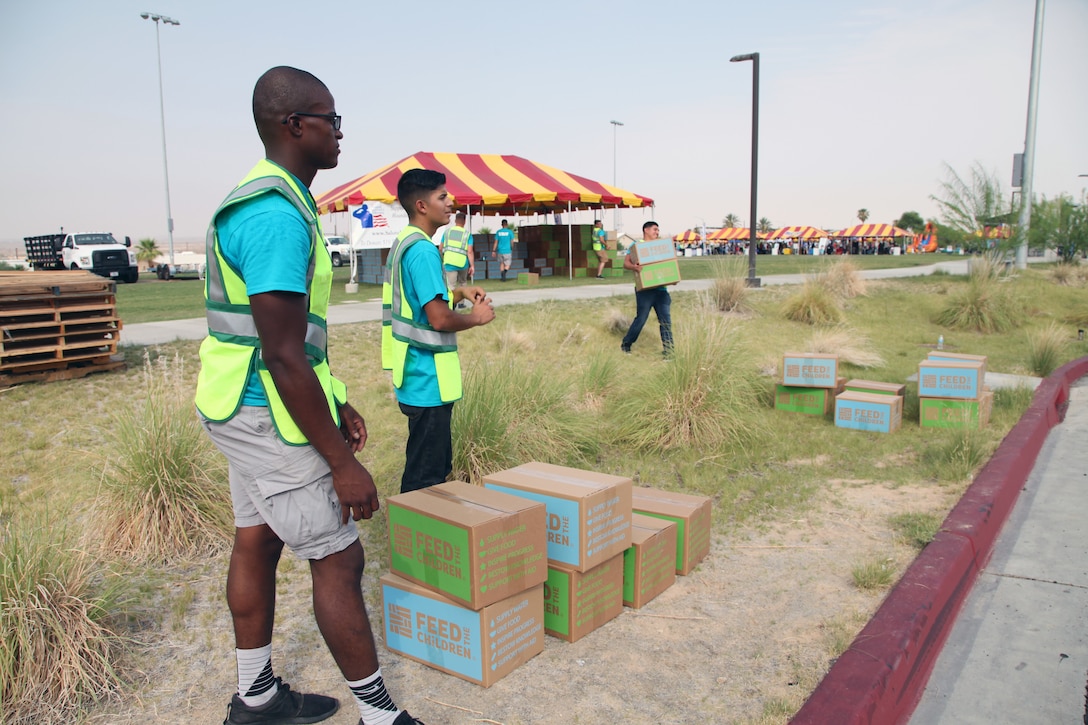 Pfc. Damontay Battle, left, and Pfc. Oscar Medina, Marine Wing Support Squadron 374, wait to load boxes packed with pantry items and toiletries into military families' vehicles during the Back to School Bash at Victory Field, Marine Corps Air Ground Combat Center, Twentynine Palms, Calif., Aug. 10, 2018. The boxes were provided by the Coalition to Support America’s Heroes in partnership with Feed the Children. About 1,500 attended the bash, hosted by Marine Corps Community Services and the Combat Center School Liaison. (Marine Corps photos by Kelly O'Sullivan)