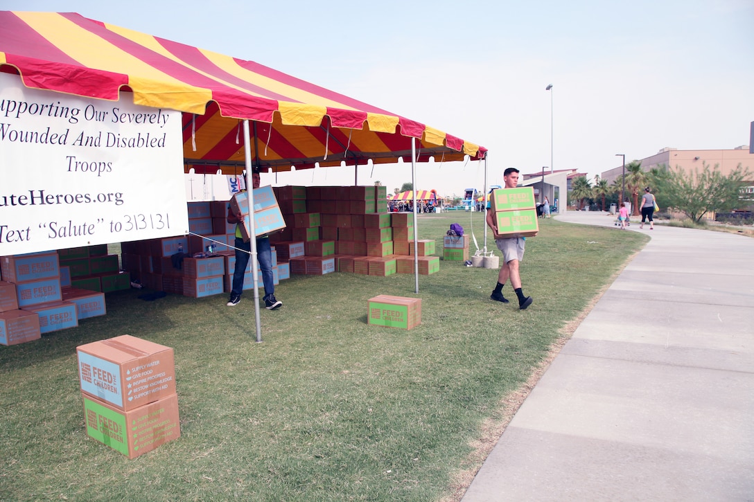 Marines with Marine Wing Support Squadron 374 carry boxes packed with pantry items and toiletries for pick up by families during the Back to School Bash at Victory Field, Marine Corps Air Ground Combat Center, Twentynine Palms, Calif., Aug. 10, 2018. About 1,500 attended the event hosted by Marine Corps Community Service and the Combat Center School Liaison. (Marine Corps photo by Kelly O'Sullivan)