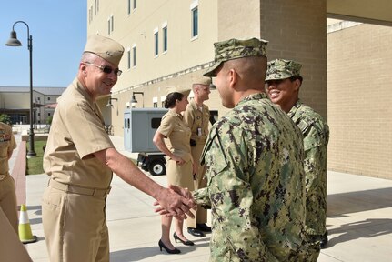 Petty Officer 1st Class Joaquin Cruz (right), an instructor at the Medical Education and Training Campus, greets Vice Adm. Forrest Faison, Navy surgeon general and chief, U.S. Navy Bureau of Medicine and Surgery during his visit to Navy Medicine Training Support Center at Joint Base San Antonio-Fort Sam Houston.