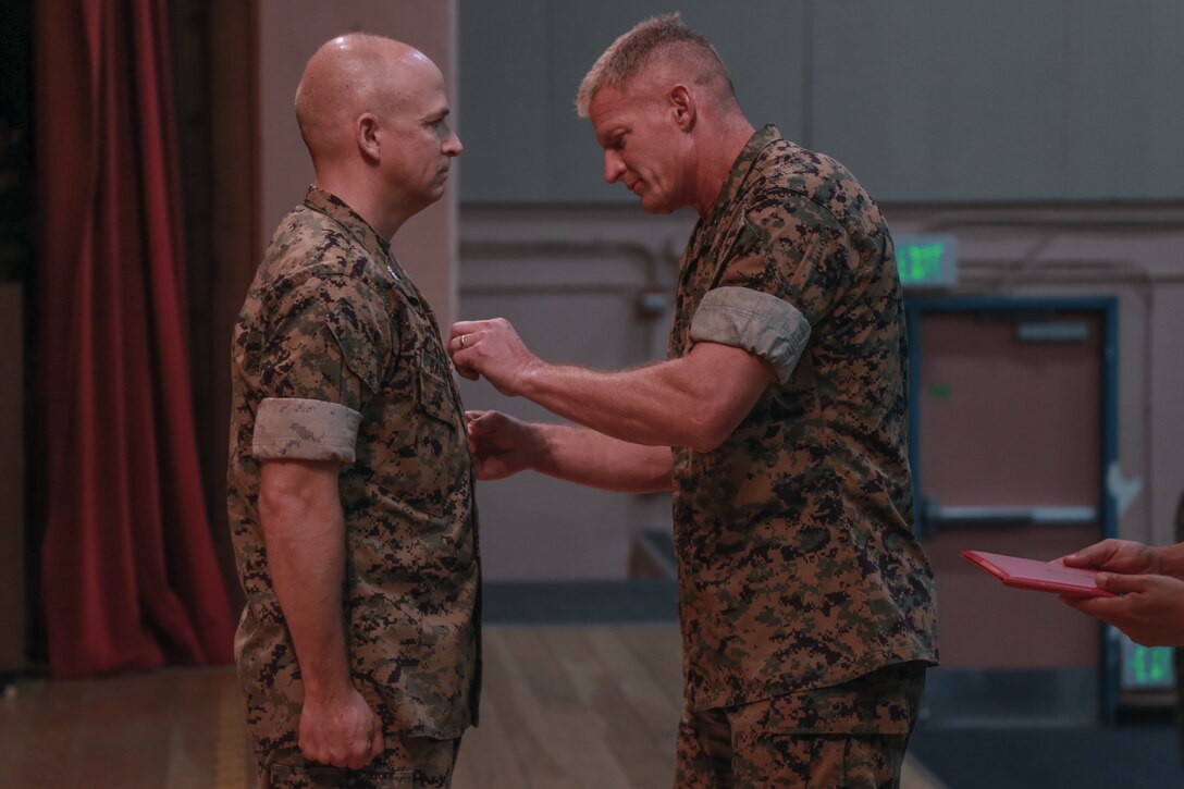 Brig. Gen. Roger Turner Jr., Commanding General, Marine Corps Air Ground Combat Center, awards Col. Timothy Barrick, off-going commanding officer, Marine Corps Tactics and Operations Group, with the Legion of Merit in a ceremony aboard the Marine Corps Air Ground Combat Center, Twentynine Palms, Calif., Aug. 10, 2018. MCTOG celebrated its 10th anniversary and conducted a change of command ceremony during which Barrick relinquished command to Col. Gregory Poland. (U.S. Marine Corps photo by Lance Cpl. Preston L. Morris)