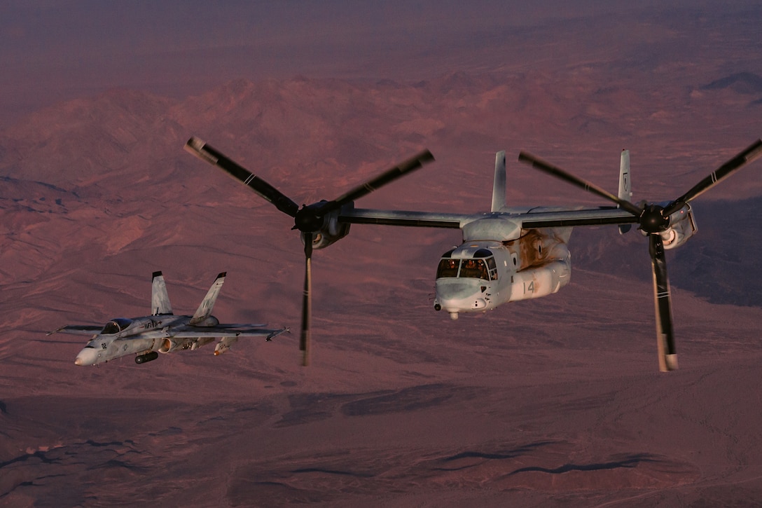 An MV-22 Osprey and a F/A18 Super Hornet with Marine Medium Tilt Rotor Squadron 165 fly in a formation as part of an aerial flight formation exercise over Marine Corps Air Ground Combat Center, Twentynine Palms, Calif., August 12, 2018. The exercise was completed as a form of demonstration of the capabilities of the VMM-165. (U.S. Marine Corps photo by Lance Cpl. Rachel K. Young)