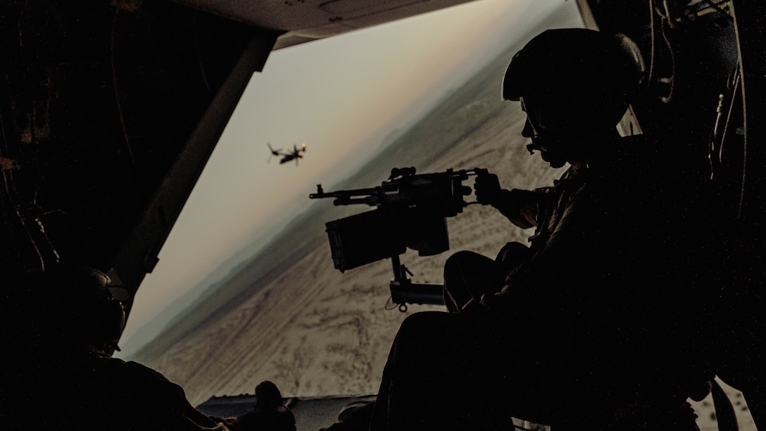 Sgt. Derek Levi, MV22 crew chief, Marine Medium Tilt Rotor Squadron, Marine Aircraft Group 16, 3rd Marine Aircraft Wing mans an M240 attached to an Osprey with VMM-165 as a part of an aerial flight formation exercise over Marine Corps Air Ground Combat Center, Twentynine Palms, Calif., August 12, 2018. The exercise was completed as a form of demonstration of the capabilities of the VMM-165. (U.S. Marine Corps photo by Lance Cpl. Rachel K. Young)