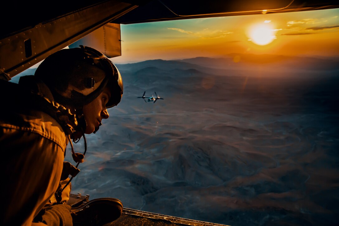 Sgt. Derek Levi, MV22 crew chief, Marine Medium Tilt Rotor Squadron, Marine Aircraft Group 16, 3rd Marine Aircraft Wing looks over the landscape of Marine Corps Air Ground Combat Center, Twentynine Palms, Calif., during an aerial flight formation exercise August 12, 2018. “I get to see the world from the sky,” said Sgt. Derek Levi, MV22 crew chief, Marine Medium Tilt Rotor Squadron, Marine Aircraft Group 16, 3rd Marine Aircraft Wing, “While I work on the ground, I get to work on the aircraft while watching young Marines become experts in their field and leaders of others.” The exercise was completed as a form of demonstration of the capabilities of the VMM-165. (U.S. Marine Corps photo by Lance Cpl. Rachel K. Young)