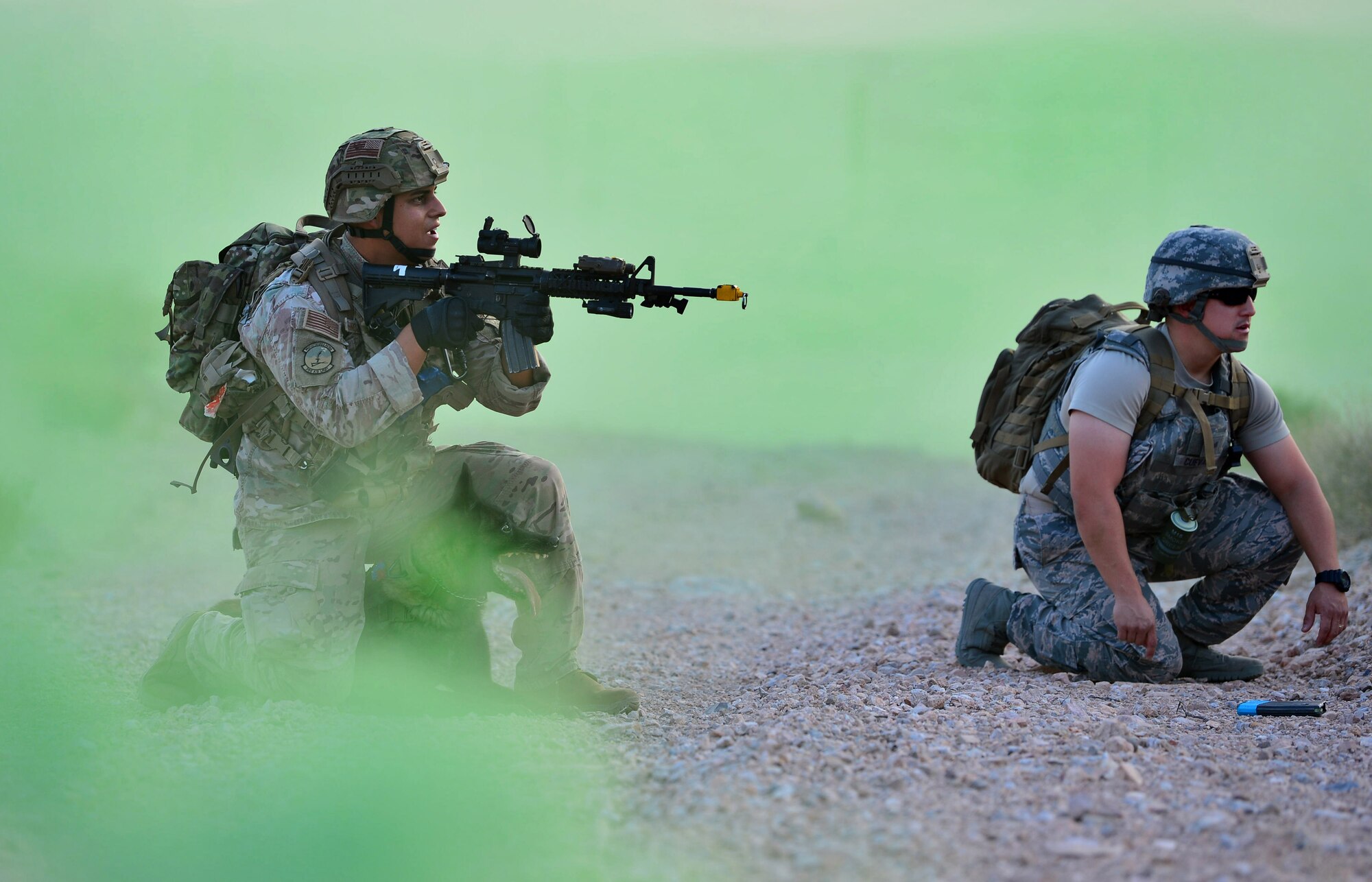 Staff Sgt. Juan Hinojosa, 99th Security Forces Squadron military working dog handler and Erik, 99th SFS MWD, respond to a simulated “live-fire” scenario during a training exercise Aug. 8, 2018, at Nellis Air Force Base, Nev. This portion of the training was to test the dog’s reaction to the sound of live gunfire and explosives while also testing how their handler would react to the situation. (U.S. Air Force Photo by Airman 1st Class Haley Stevens)