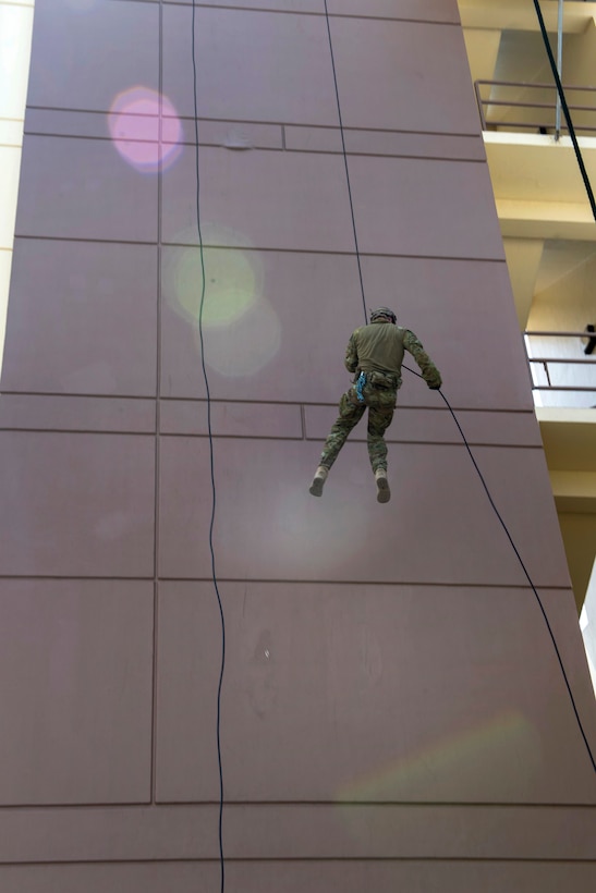An Australian soldier repels from a tower during unit-level training.