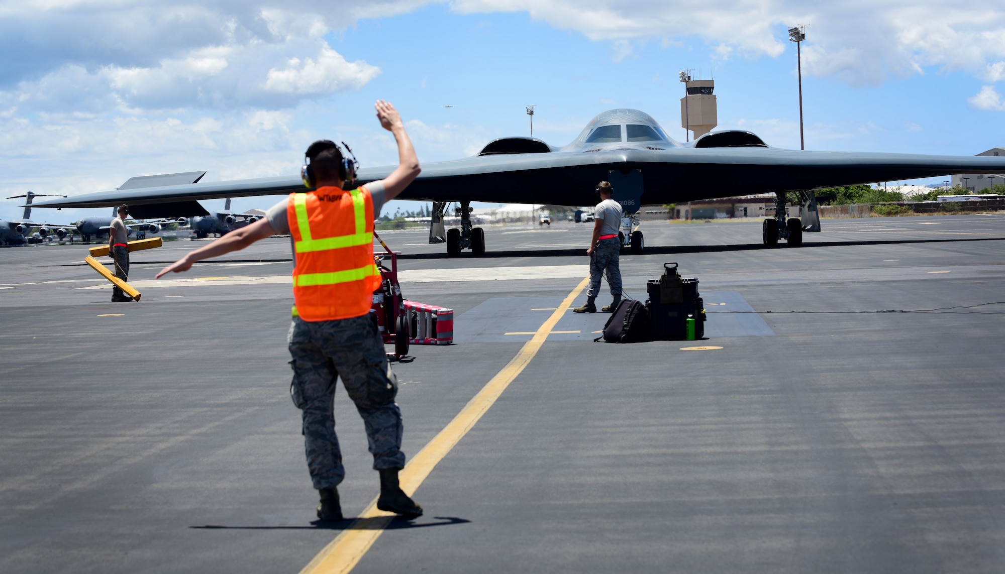 A U.S. Air Force maintenance technician from Whiteman Air Force Base, Missouri, marshals a B-2 Spirit at Joint Base Pearl Harbor-Hickam, Hawaii, Aug. 15, 2018. B-2s regularly rotate through the Indo-Pacific to conduct routine air operations, which integrate capabilities with key regional partners and demonstrate U.S. commitment to peace and stability in the region. These operations are in support of the U.S. Strategic Command’s Bomber Task Force deployment. (U.S. Air Force photo by Staff Sgt. Danielle Quilla)