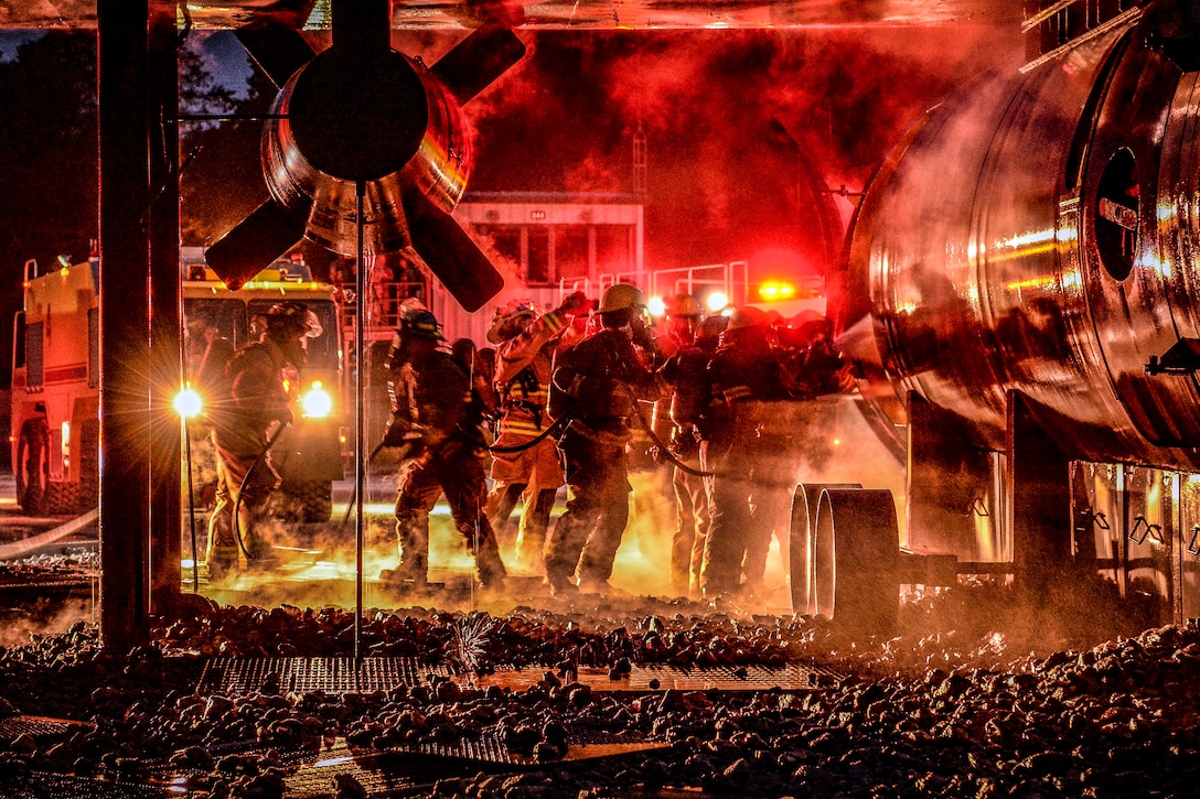 Firemen prepare to fight a nighttime fire.