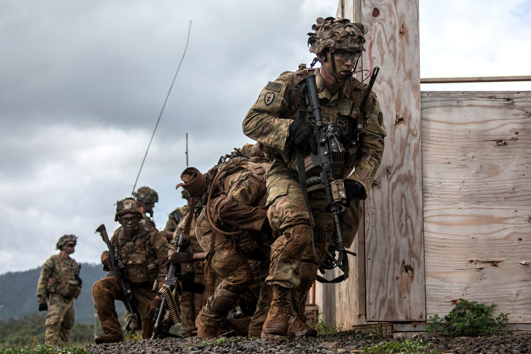 Soldiers move toward another building as they clear an objective.