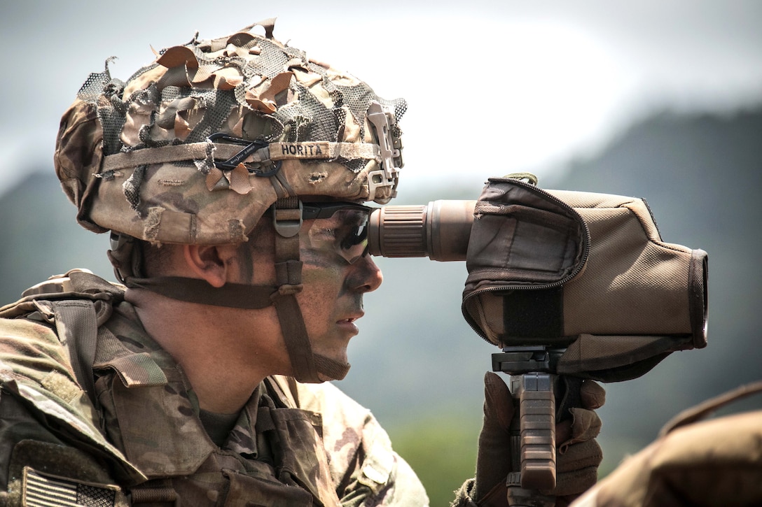 A soldier indicates targets for a sniper.