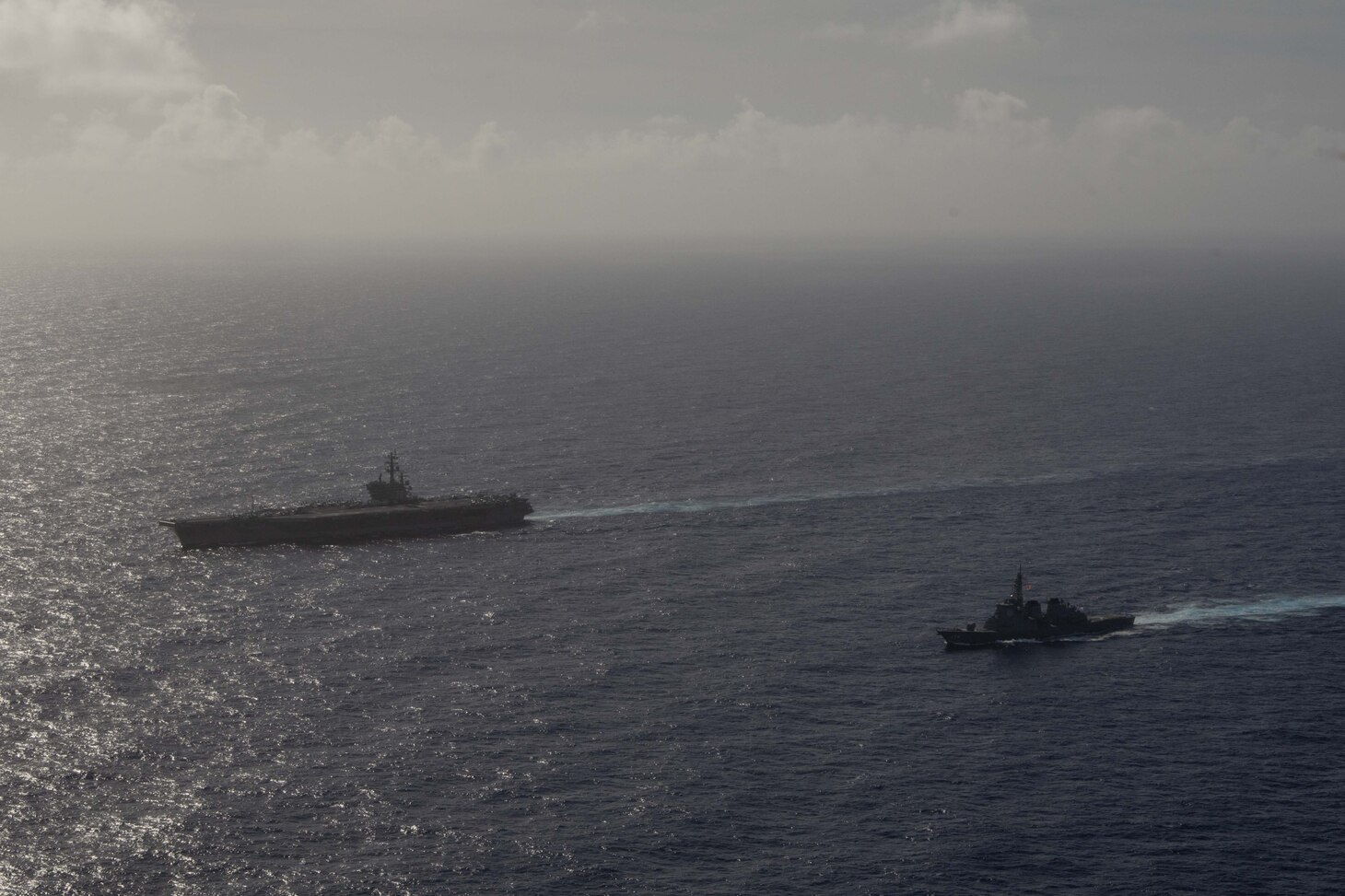 PHILIPPINE SEA (Aug. 15, 2018) The Kongo-class guided-missile destroyer JS Kirishima (DDG 174), right, sails alongside the aircraft carrier USS Ronald Reagan (CVN 76) during photo exercise. Ronald Reagan is forward-deployed to the U.S. 7th Fleet area of operations.