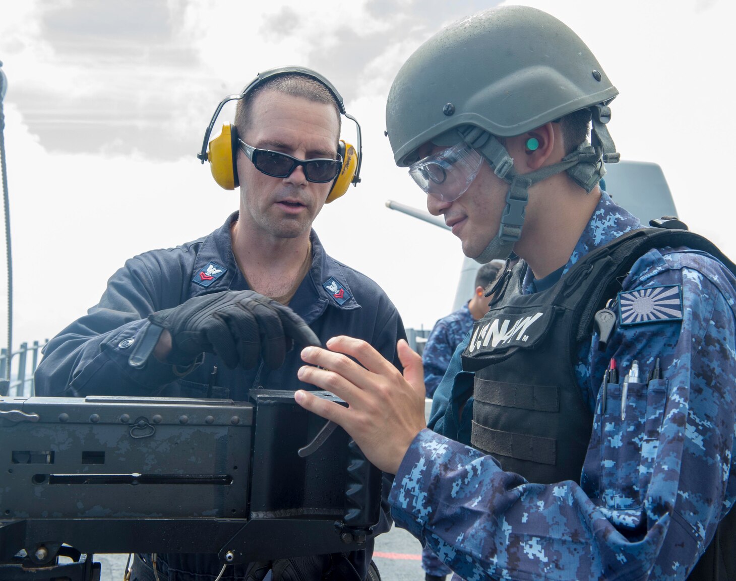 SEA OF JAPAN (August 15, 2018) Gunner’s Mate 2nd Class Matthew Spano (left), from Phoenix, instructs Ensign Taisei Sakai, assigned to the Kongo-class guided-missile destroyer JDS Kirishima (DDG-174), Japan Maritime Self-Defense Force (JMSDF), during a live-fire exercise with a M2HB .50 caliber machine gun on the Ticonderoga-class guided-missile cruiser USS Antietam (CG 54). Antietam is on patrol in the U.S. 7th Fleet area of operation supporting security and stability in the Indo-Pacific region.